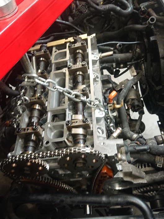 Een geopende motor met de nokkenassen en de distributieketting zichtbaar