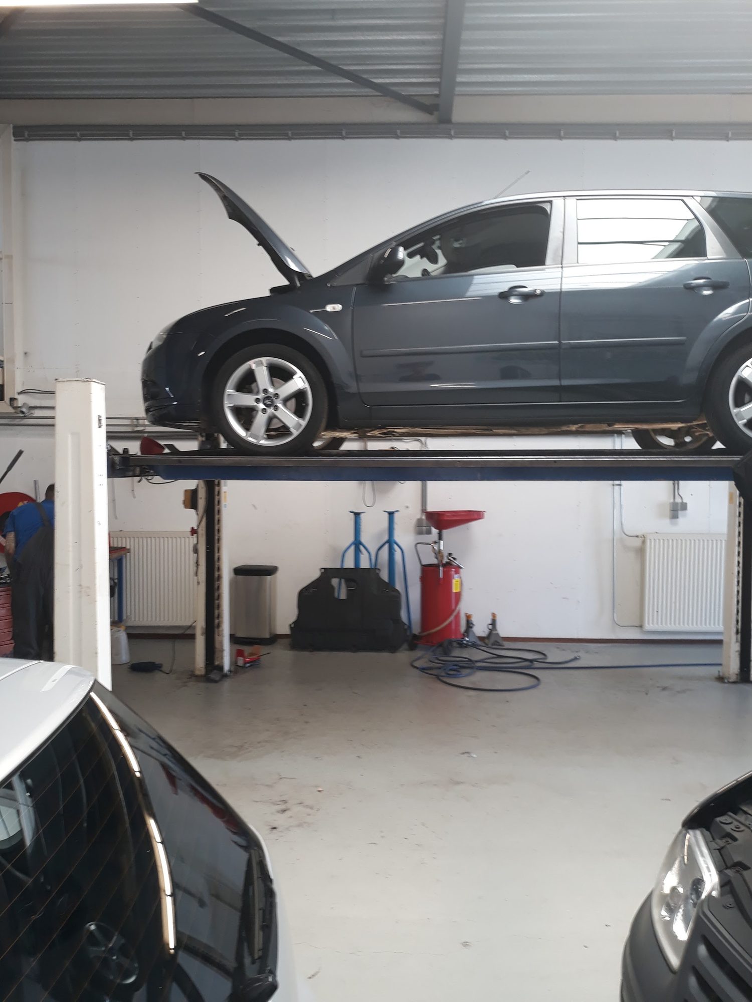 Een donkere Ford Focus op de brug in de werkplaats